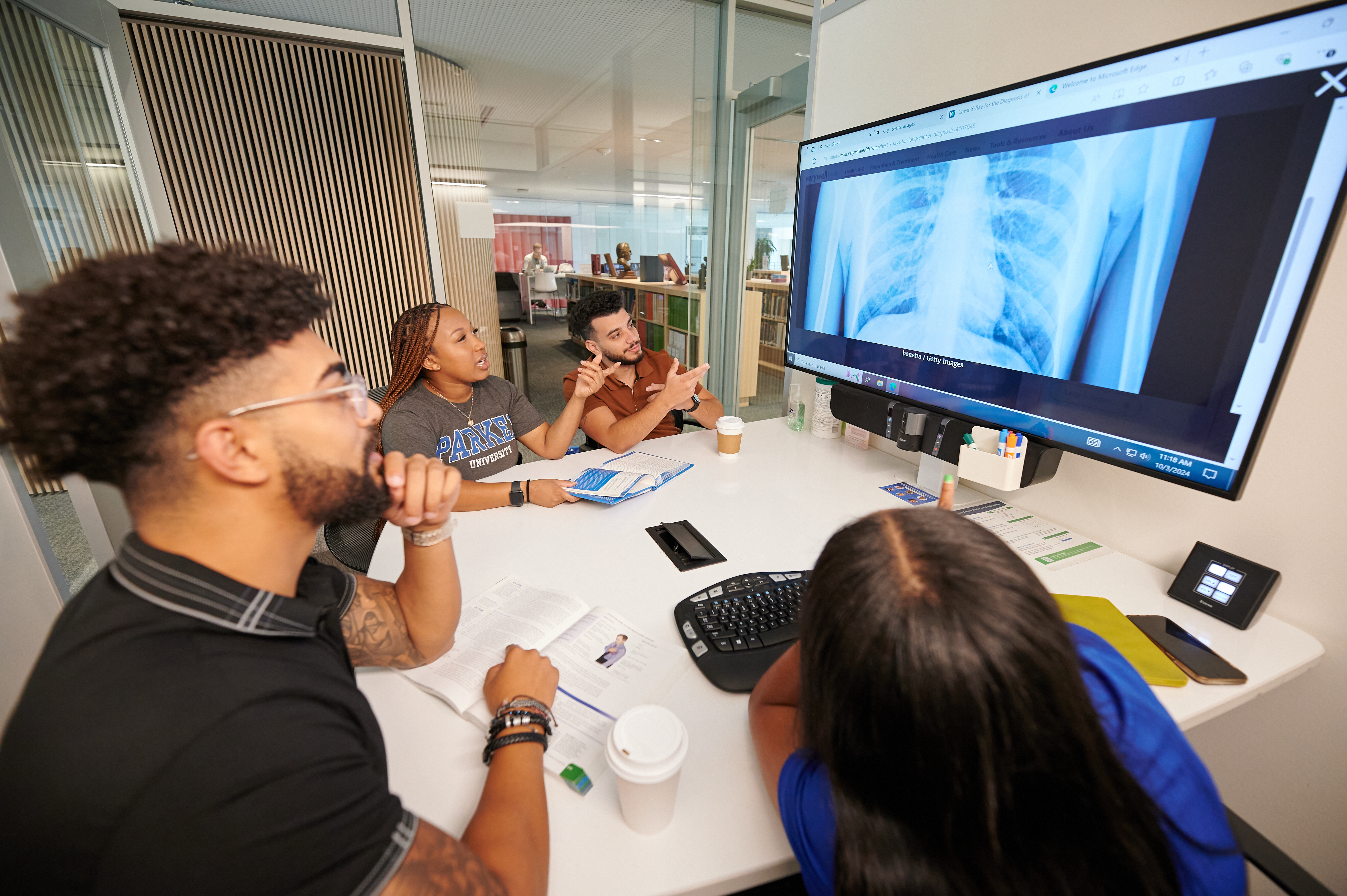 A group of students using a library huddle room